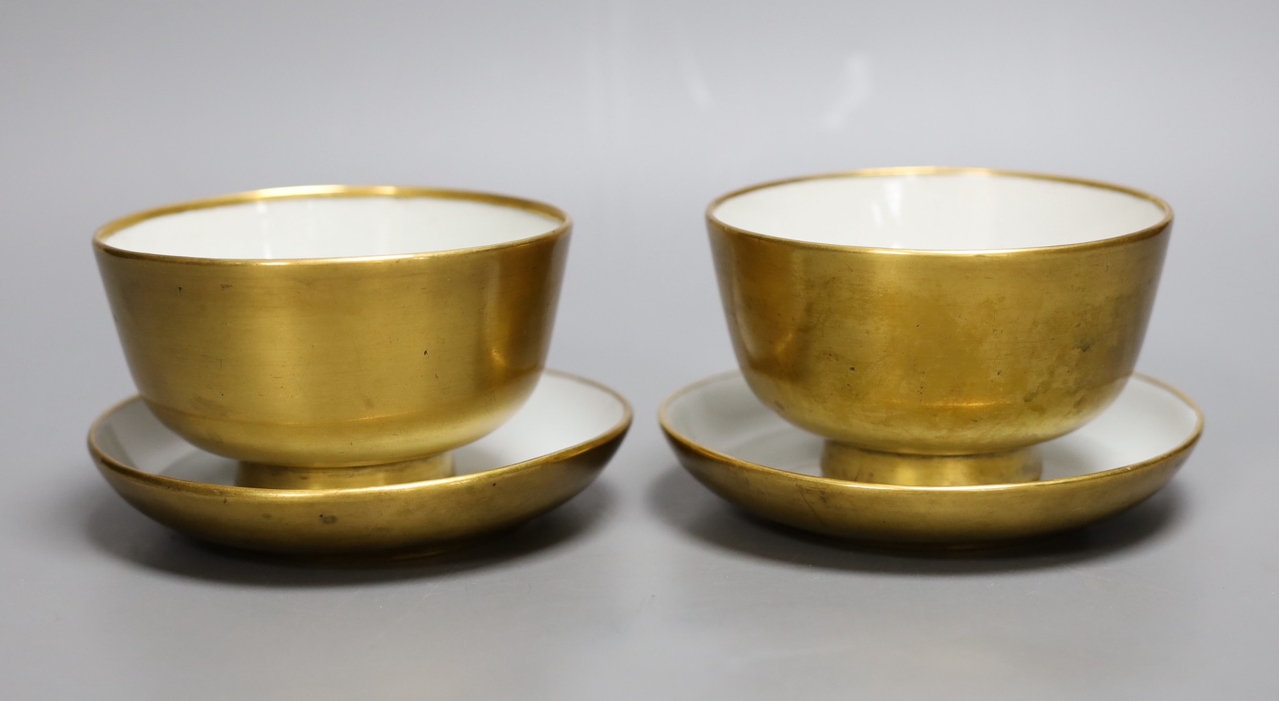 A pair of Paris porcelain gilded tea bowls and saucers , first half of 19th century, saucer 13cms diameter